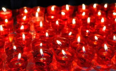 Firing candles in catholic church in red chandeliers - 54526626