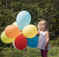 Fototapeta na wymiar little girl plays with balloons