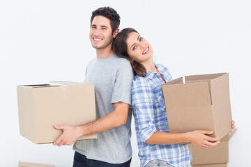 Wife and husband carrying boxes in their new house