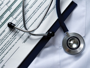 A stethoscope and a clipboard on a medical uniform, closeup