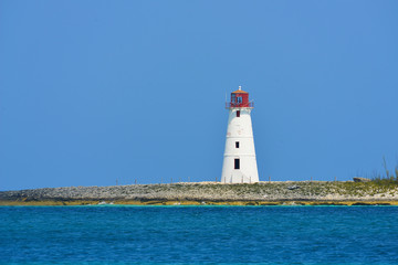 Fototapeta na wymiar Lighthouse seen from a tiny beach in Nassau - Bahamas.