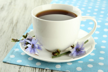 Cup of tea with chicory, on wooden background
