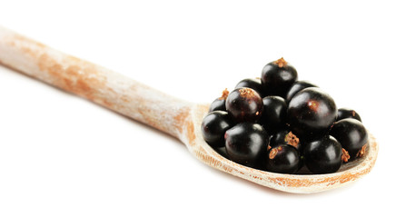 Black currant in wooden spoon isolated on white