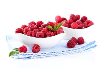 Ripe sweet raspberries in bowls, isolated on white