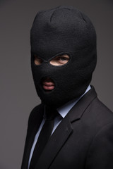 White collar crime. Portrait of businessman in black balaclava l