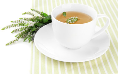 Cup of herbal tea with fresh mint flowers isolated on white