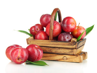 Ripe plums in basket isolated on white