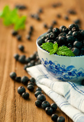 bowl of blueberries on a wooden background