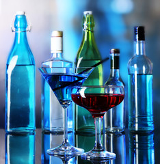 Glasses of cocktails on bright background