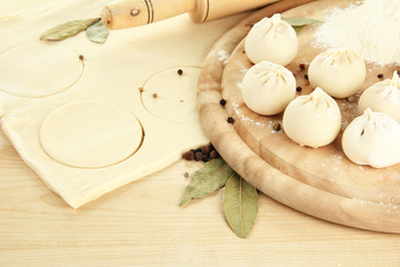 Raw dumplings and dough, on wooden table