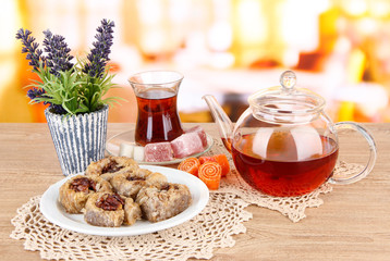 Sweet baklava on plate with tea on table in room