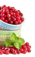 Ripe red cranberries in bowls, isolated on white.