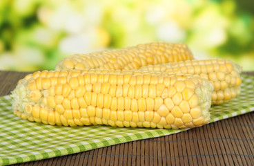 Fresh corn on bamboo mat, on bright background