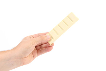 Hand holds bar of white chocolate.