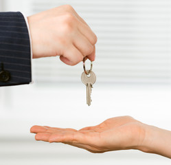 Real estate broker handing a key of a new flat to a woman