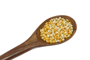 yellow corn grain and spoon isolated on white background