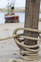 The rope tying boat with a wooden post