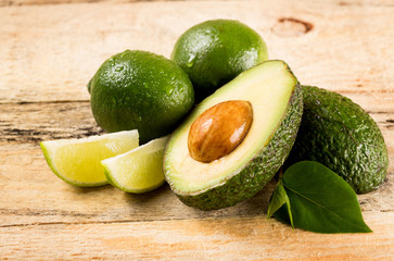 avocado and limes on wooden background © Syda Productions