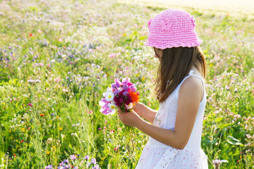 bimba a racogliere i fiori