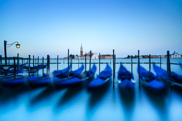 Venice, gondolas on sunset and church on background. Italy