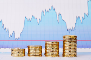 Uptrend stacks of golden coins and  financial  chart as backgrou