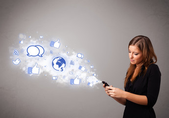 Pretty young girl holding a phone with social media icons
