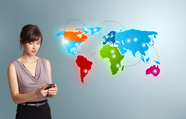 Young woman holding a phone and presenting colorful world map
