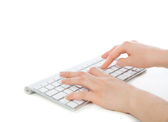 Hands typing on the remote wireless computer keyboard
