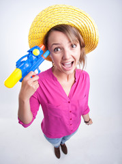 pretty girl wearing a hat holding a water gun looking cheerful