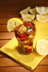 Iced tea with raspberries and mint on wooden table
