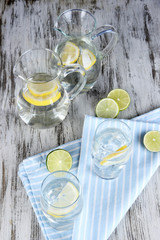 Glass pitchers of water and glasses on wooden table close-up