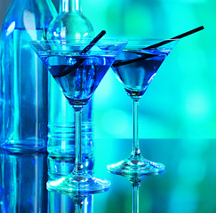 Glasses of cocktails on bright background