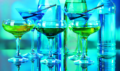Glasses of cocktails on bright background