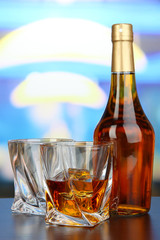 Glass of whiskey with bottle, on dark background