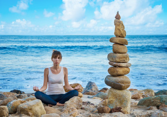 Yang woman practicing yoga by the ocean