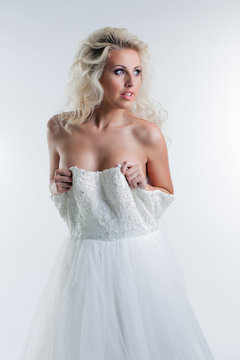 Sensual young blonde taking off wedding dress