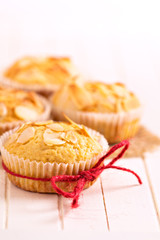 Almond muffins with red twine on a wooden table