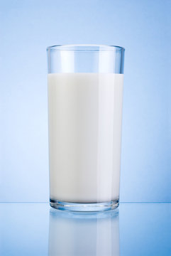 Glass of fresh milk isolated on a blue background