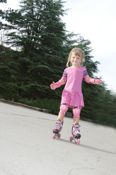 young happy girl riding roller blades outdoors