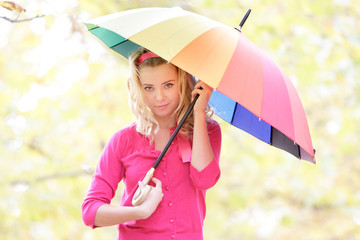 young happy woman with colorful umbrella in autumn park