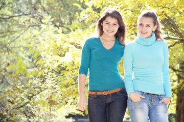 two young happy girls in autumn park outdoor portrait