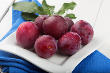 Fresh plums  in bowl on table