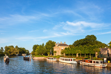 Fototapeta na wymiar Klasyczne małe łodzie wycieczkowe na słynnej holenderskiej rzeki Vecht