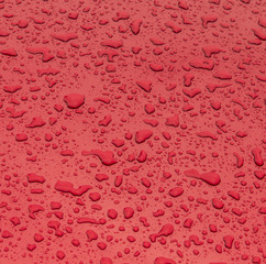 red pattern of raindrops at a metal surface