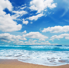 frothy shore and scenic clouds