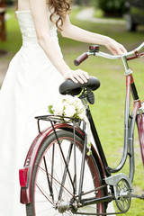 Obraz premium Photo of bride and wedding bouquet on a bicycle