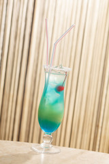 blue cocktail with cherry