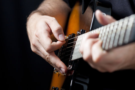 Close up on  hands playing on electric guitar