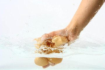 Eggs in hand into clear water splash