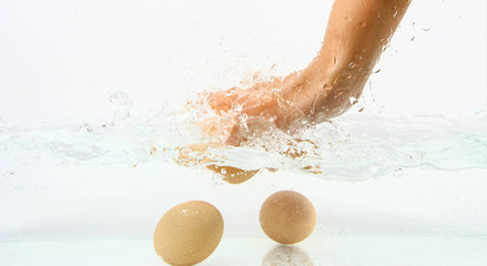 Eggs in hand into clear water splash